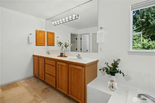The spacious primary bathroom is a true retreat with dual sinks, a soaking tub, shower and plenty of cabinetry and closet storage.