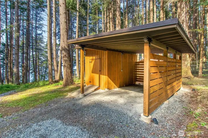 Carport with storage space is near the main cabin.