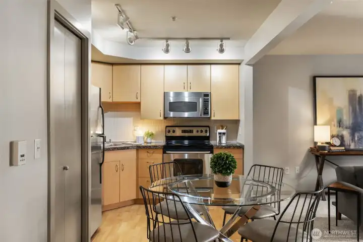 Laundry closet, deco tile backsplash, cable lighting, and plenty of cabinetry.