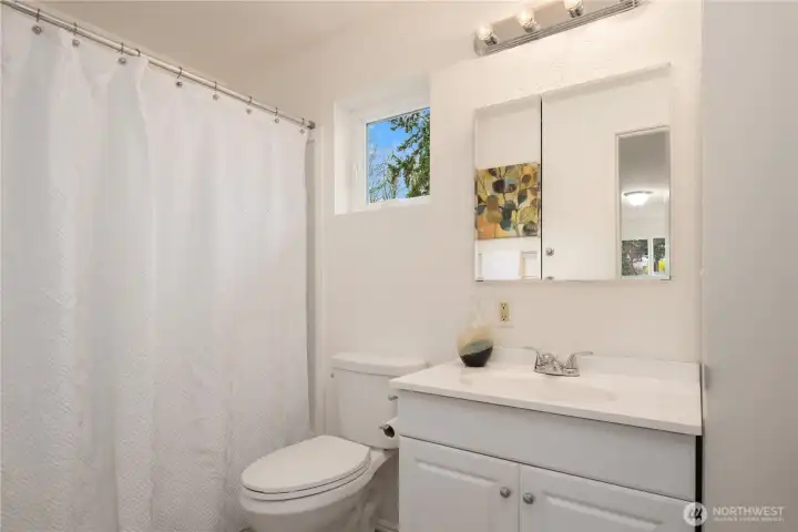 The ADU bath is a full bath with a tub, vanity and extra storage closet.