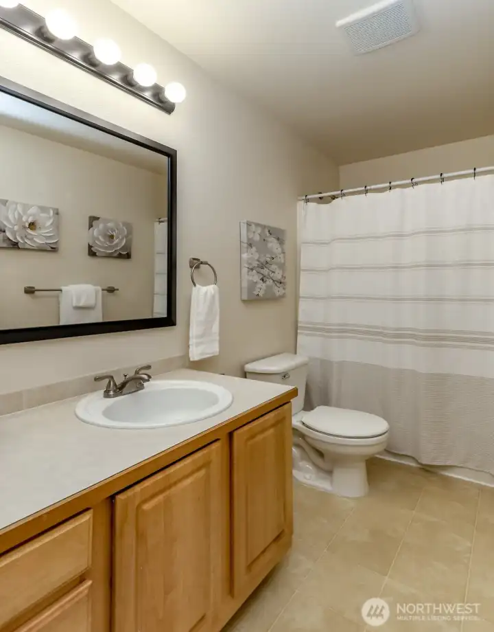 Full bathroom just off extra bedrooms in hallway.