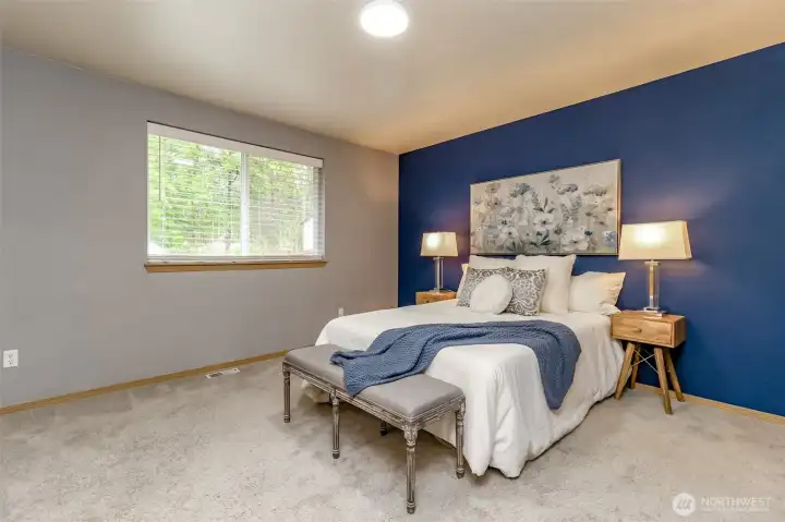 Primary bedroom which overlooks the back yard and green space and not backing up to other homes so enjoy. this private backyard space.