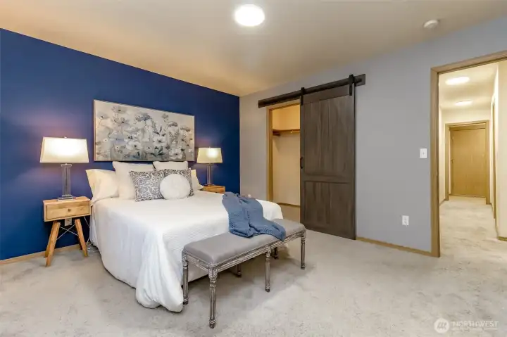 Primary with walk in closet. The door leads to the hallway, extra bedrooms, bathroom and the utility room at the end of the hall.