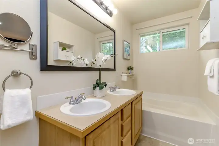 Primary bathroom with soaking tub and double sink vanity.