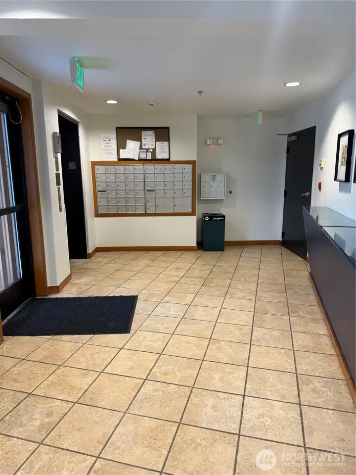 Lobby area. Entrance and elevator on left, mailboxes ahead and package area on right counter. Lobby area. Entrance and elevator on left, mailboxes ahead and package area on right counter.