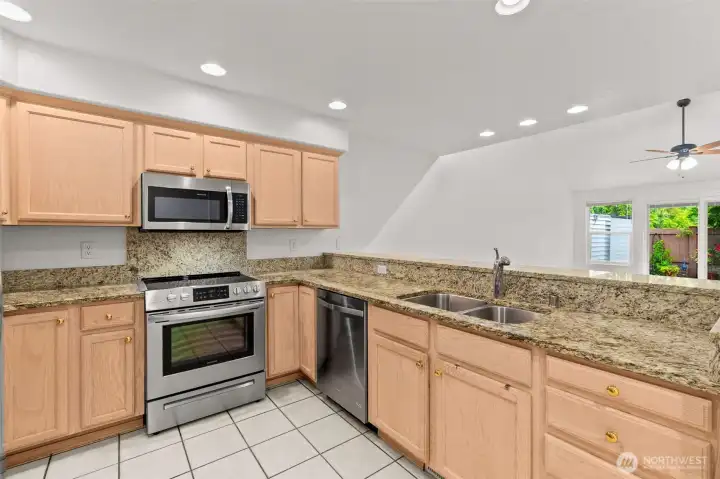 The spacious kitchen offers a stainless steel appliance suite and granite countertops, open to the great room and backyard windows. The spacious kitchen offers a stainless steel appliance suite and granite countertops, open to the great room and backyard windows.