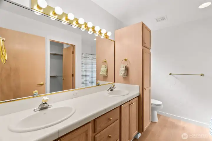 Double sinks, full-width mirror, easy entry shower, great storage, and window for natural light make this primary bathroom a favorite. Double sinks, full-width mirror, easy entry shower, great storage, and window for natural light make this primary bathroom a favorite.
