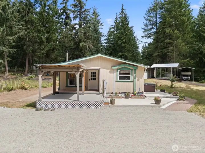 Welcoming home with large wrap around patio and front parking area.
