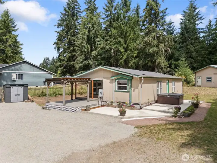 Exterior view with large patio and hot tub.