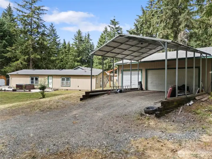Exterior view of 3 car garage and 2 car carport.