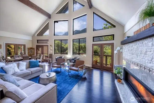 Main lodge boasts soaring ceilings, multiple access points to expansive decks, and a breathtaking wall of windows that perfectly frame the mountain views.
