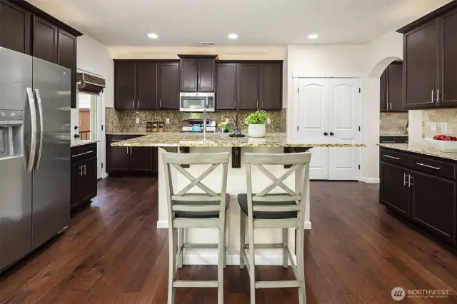 Excellent kitchen layout with granite counters, island, fantastic storage, wide pantry, and stainless steel appliances.