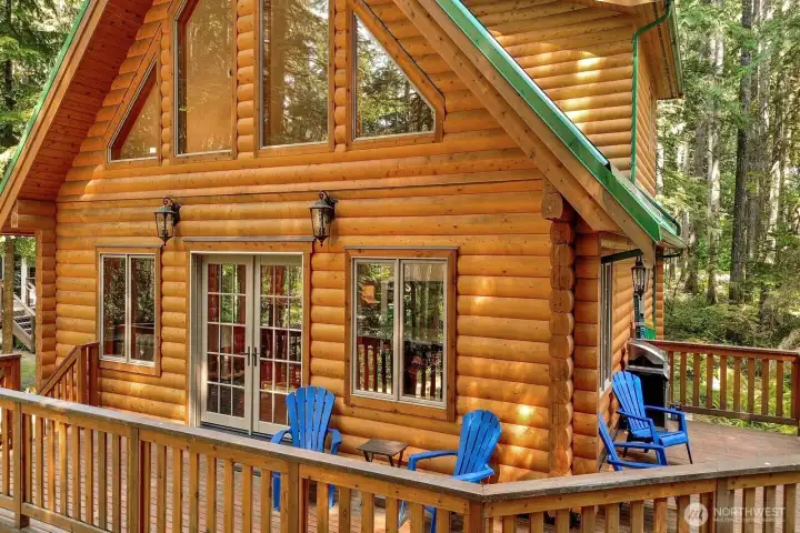 Porch wraps around the side of the log home