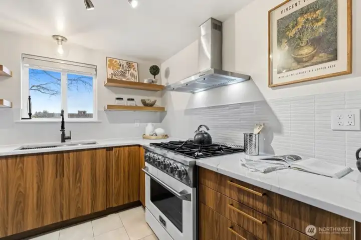 gas range, beautiful cabinetry, counters, sink and lighting
