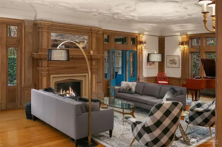 The living room is anchored by a gas fireplace. At approximately 37 feet by 20 feet, there is room for multiple seating areas as well as a grand piano.