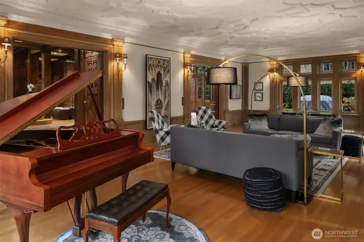Another photo of the living room. The foyer is accessed through the entry just above the piano. The dining room is accessed through the second entry to the right.