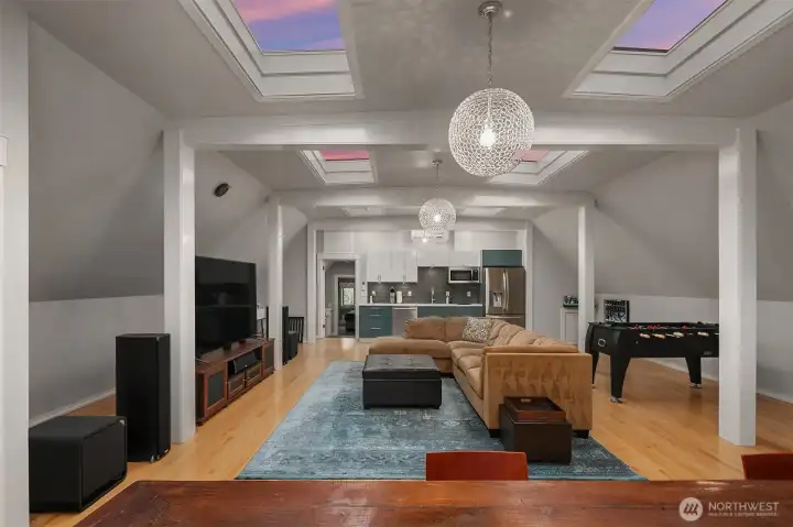 The family room is approximately 36 feet by 26 feet 8 inches. It is HUGE. The full kitchenette features a 2 burner stove, a built-in microwave, a dishwasher and a full-size refrigerator. Note the skylights.