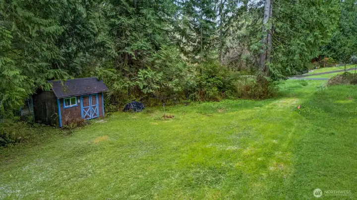 Existing outbuildings for storage, and a tranquil woodland backdrop.