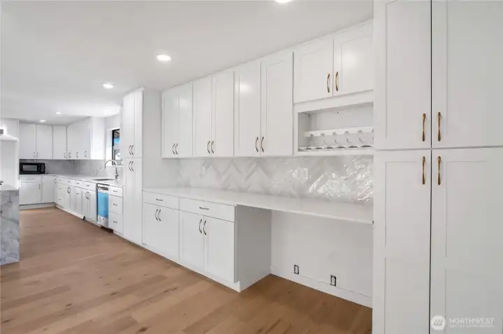 Open-concept kitchen with expansive prep space, recessed lighting, and seamless flow to living and dining areas overlooking Moses Lake