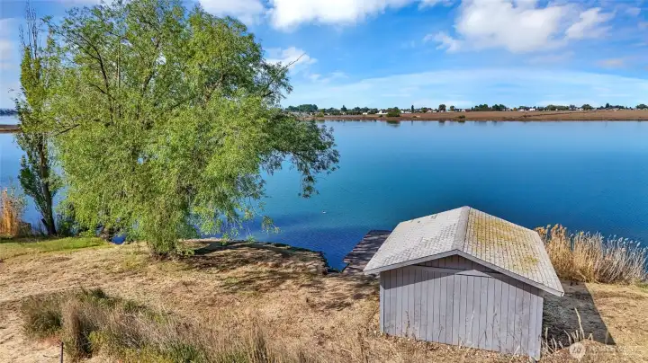 Elevated view overlooking dock, boathouse, and 90’ of Moses Lake waterfront with open water and shoreline visibility