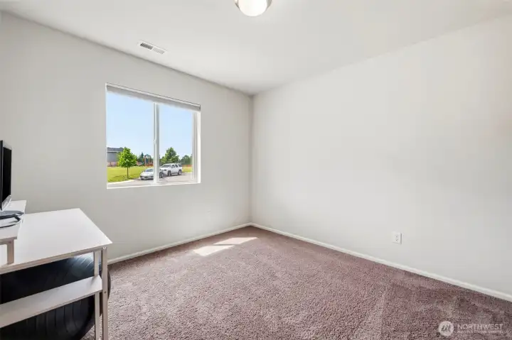 Comfortable carpeted office/den on main level with a large window overlooking the neighborhood park — a peaceful, light-filled retreat.