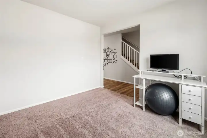 Versatile main-level space perfect for a home office, gym, or play area, located just off the staircase.
