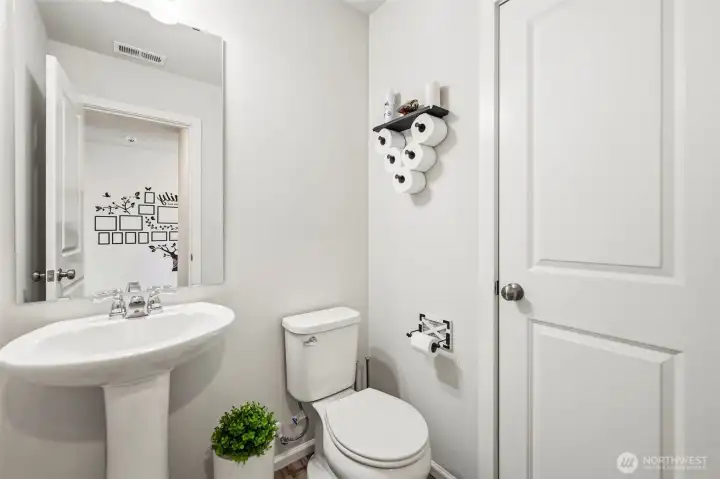 Convenient main-floor half bath with a pedestal sink and clean, bright finishes.