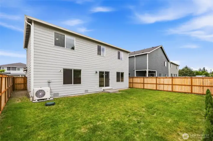 Fully fenced backyard with a level, lush lawn and an efficient ductless mini-split system for year-round comfort. Sliding glass door opens to a private outdoor space.