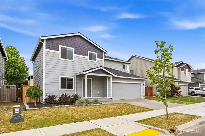 Charming two-story home with crisp gray siding, shake-accent gable, covered front porch, and an attached two-car garage.