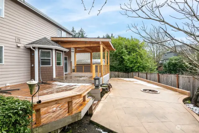 Rear cover deck with built in seating. Stamped concrete with fire pit and power stub for hot tub.