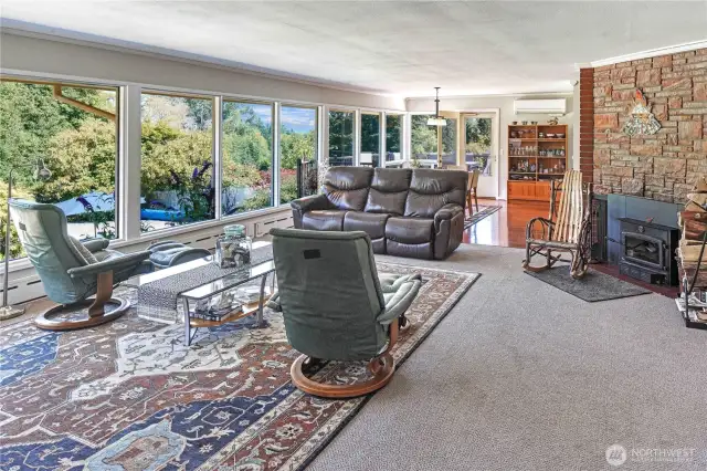 Glide from the spacious main level living room into the dining room, which is aligned with the kitchen. The house has a new heat pump system for year-round comfort, powered by solar panels! Or cozy up to your wood stove on cool winter nights for added ambience.