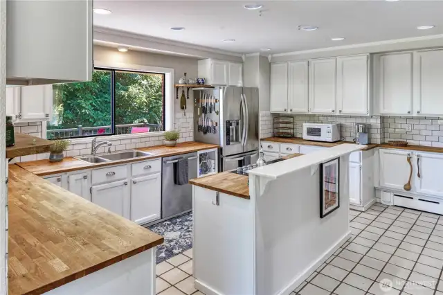 Extensive counter space for cooking and prepping meals in this spacious kitchen. Check out all of those cupboards!