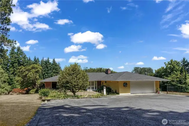 Notice the level access from the parking pad, to paved sidewalk and onward to the front doors. There is an additional entrance to the right of the garage that takes you to the south-facing deck and the doggy run.