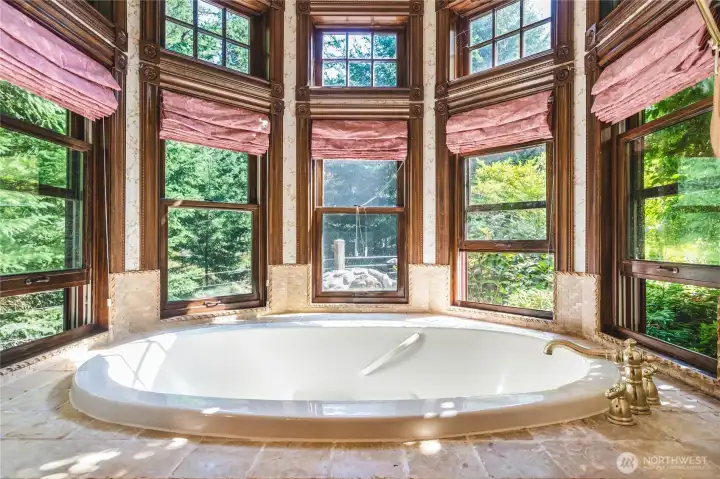 Primary bath with soaking tub and views of the surrounding gardens
