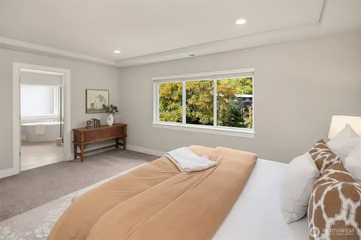 Primary bedroom with 5 piece en-suite bathroom, peaceful views and recessed ceiling detail.