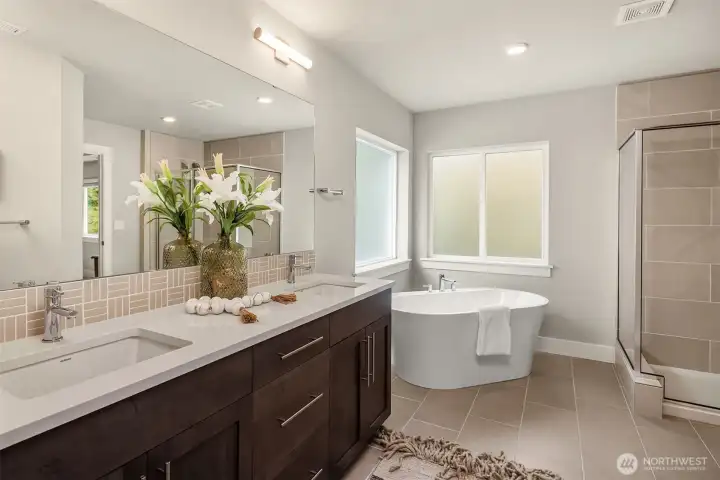 Spacious primary bath with spa like soaking tub, separate tile shower, double sink vanity and water closet.