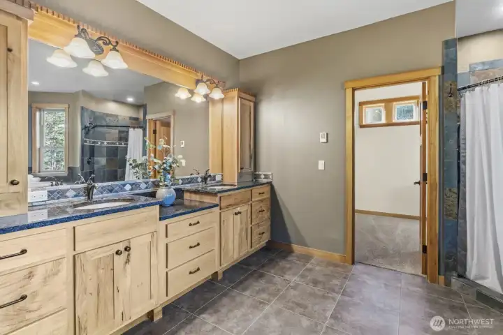 Primary bathroom has floor heating and Stone Countertops with Custom Wood Cabinets