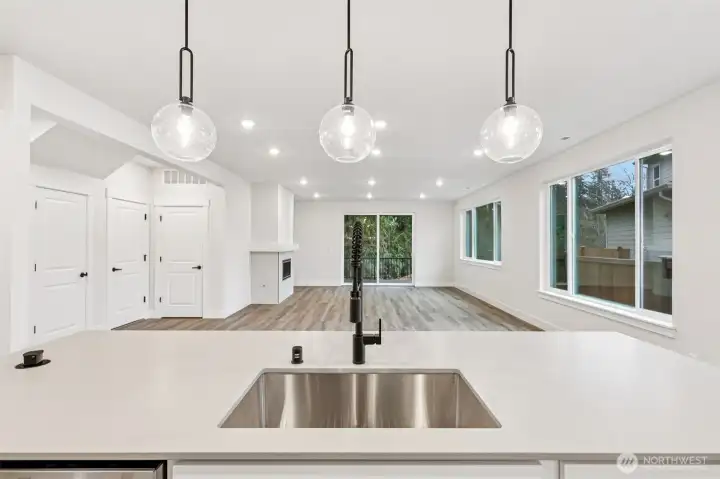 Wow, just wow.  Gorgeous quartz counter slabs throughout; undermount single basin sink with upgraded spring faucet.  Popup outlet at counter, GE appliances and large walk-in pantry.