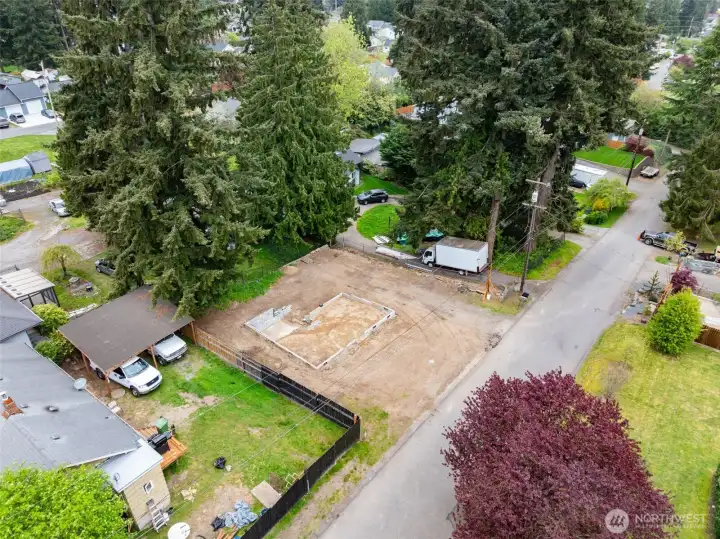 Full-site aerial showing access, neighboring properties, and development potential. Cleared lot with utilities nearby and ready for your next project.