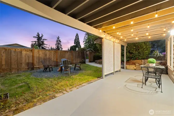 Exterior of the home showing expansive  deck, attached garage, and large fenced lot  with room to play and entertain.