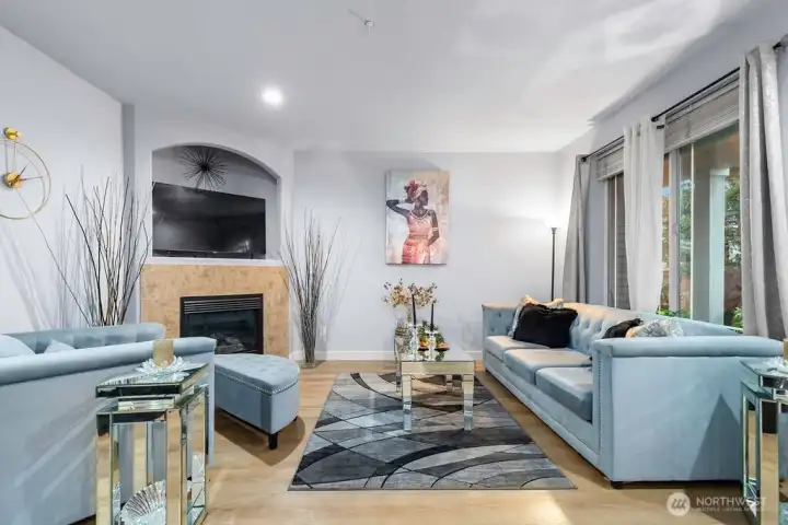The light oak-style laminate/hardwood provides a warm contrast to the cool gray walls.