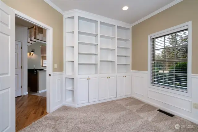 Office on the main level features wainscoting and a custom bookcase with great storage. The bookcase has adjustable shelves.