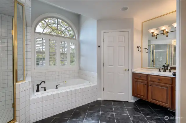 Primary bathroom features double sinks, one on each side of the bathroom. It also features a walk in shower with a bench. There is a jetted tub in the primary bathroom. The primary bathroom also has a newer toilet.