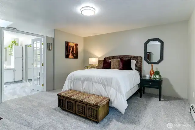 Primary bedroom with French door bathroom entrance.