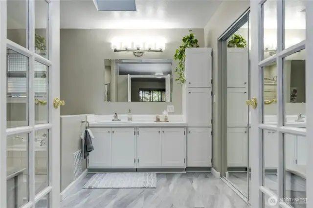 Large primary bathroom with walk-in closet with mirror closet doors.