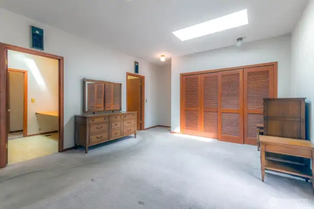 Primary ensuite, showing closet, room used as office to the left, and bathroom door upper left.
