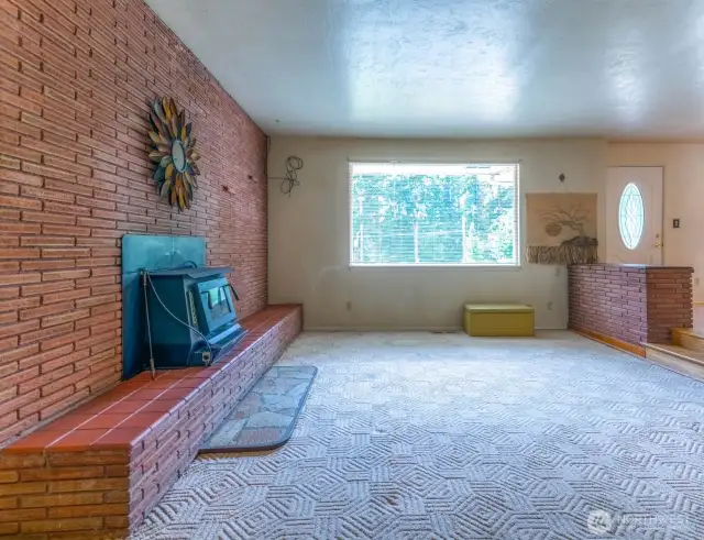 Beautiful brick fireplace, wood insert, hearth in large living room.