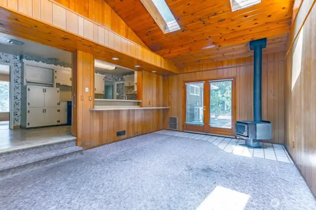Warm wood paneling, sky lights, wood stove and two sets of French Doors leading to patio and outdoor entertaining.