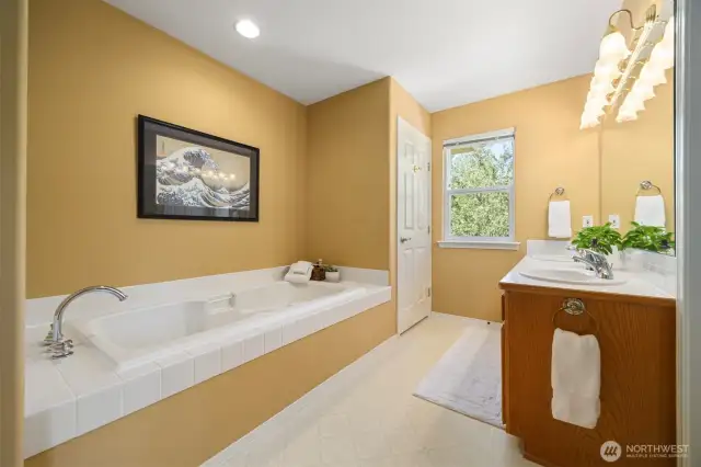 Main bathroom features two sinks and a jet tub and a toilet and shower closet