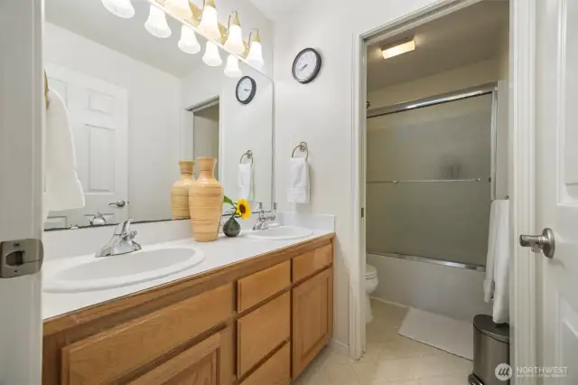 Shared bathroom with two sinks and toilet and shower closet